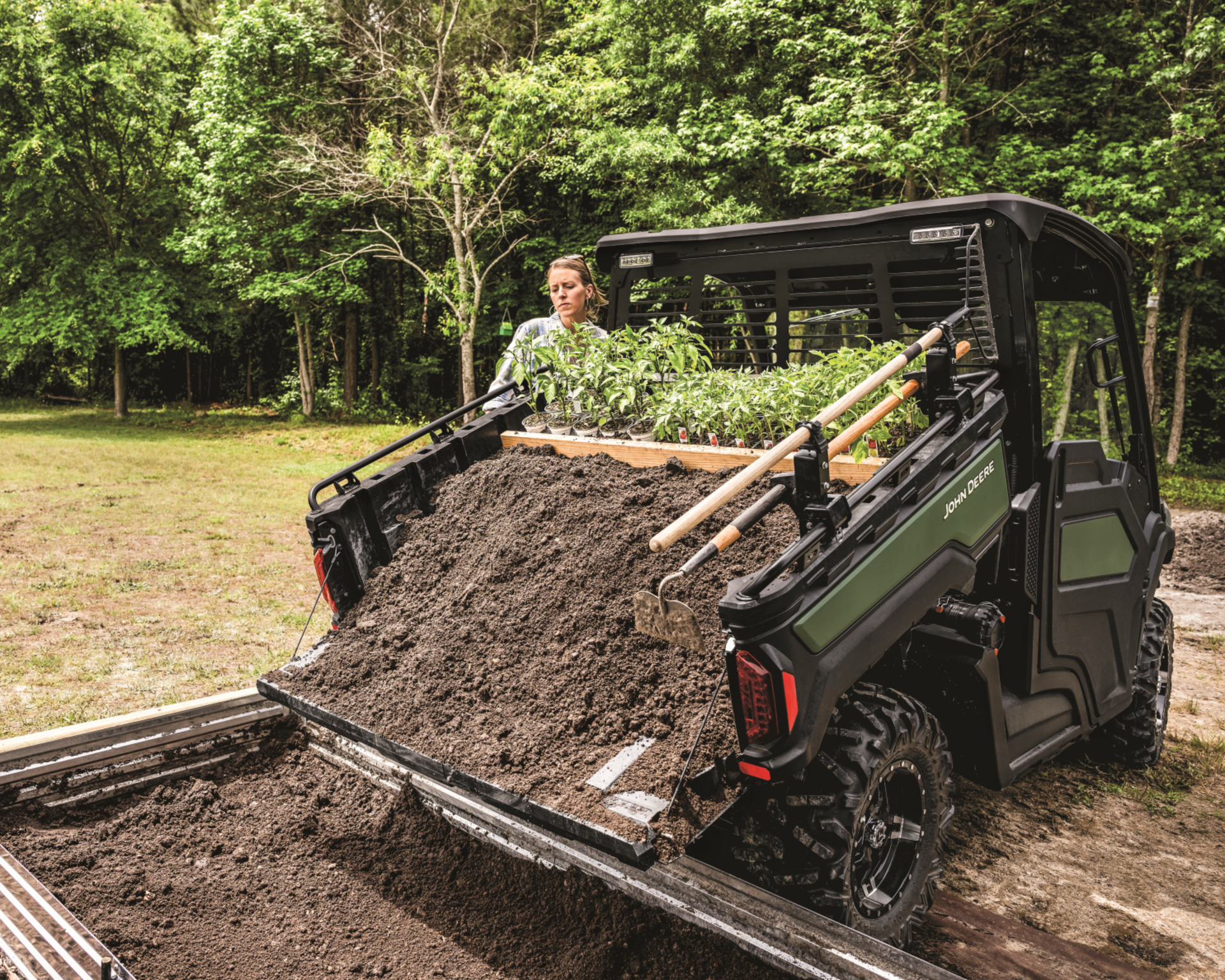 A Gator electric bed dumps dirt on a garden plot in Texas.