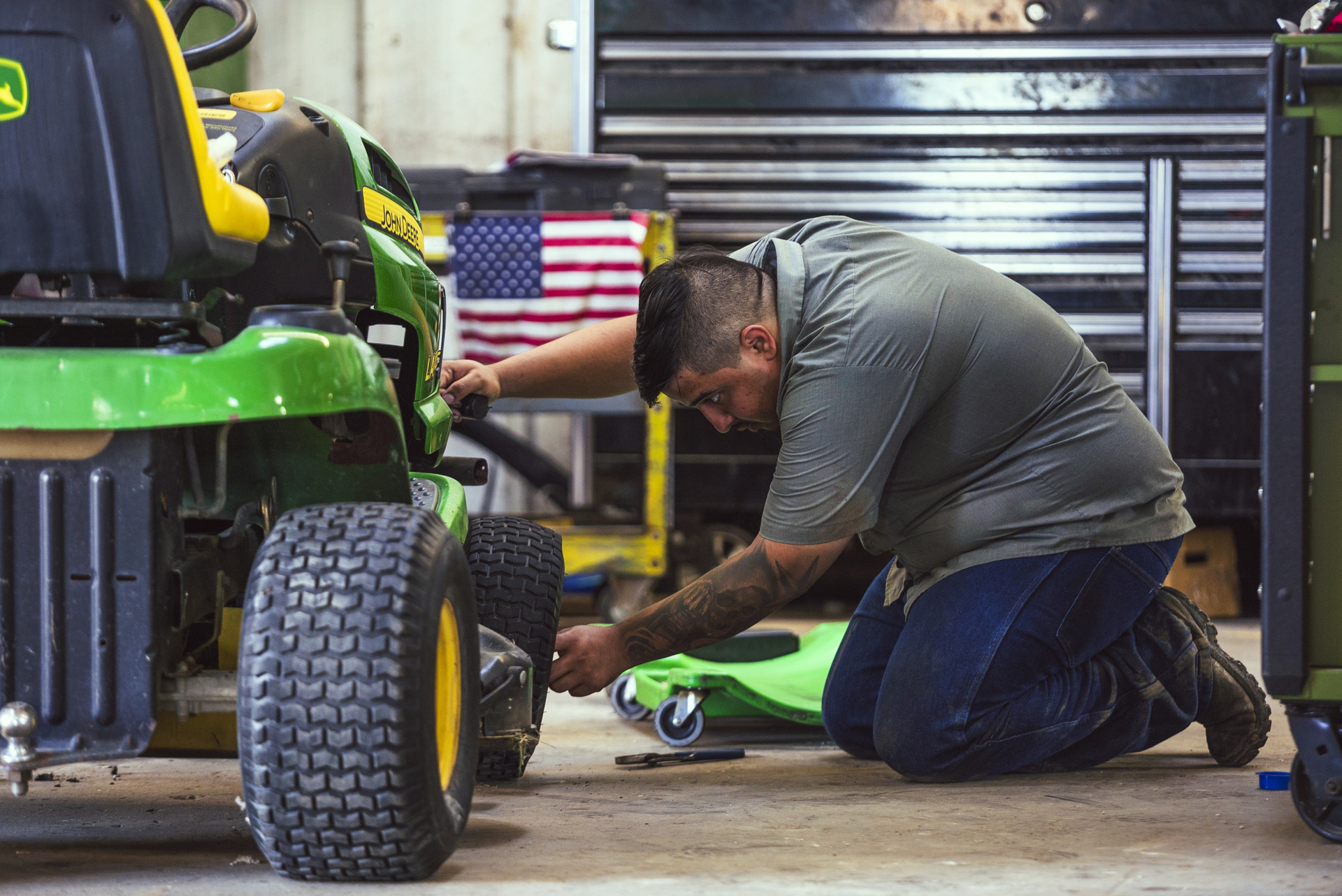 A maintenance worker at Tellus Equipment in Texas checks a lawnmower for repairs.