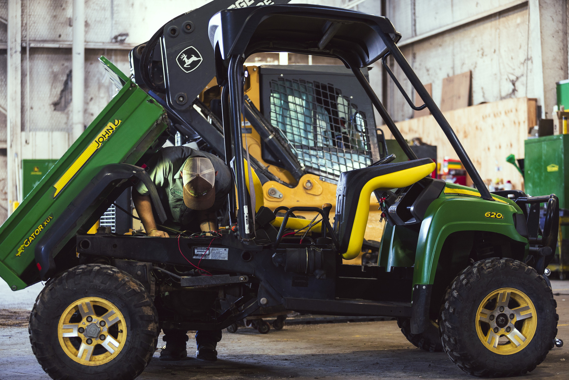 A John Deere Gator with an electric dump bed is worked on by a Tellus technician.