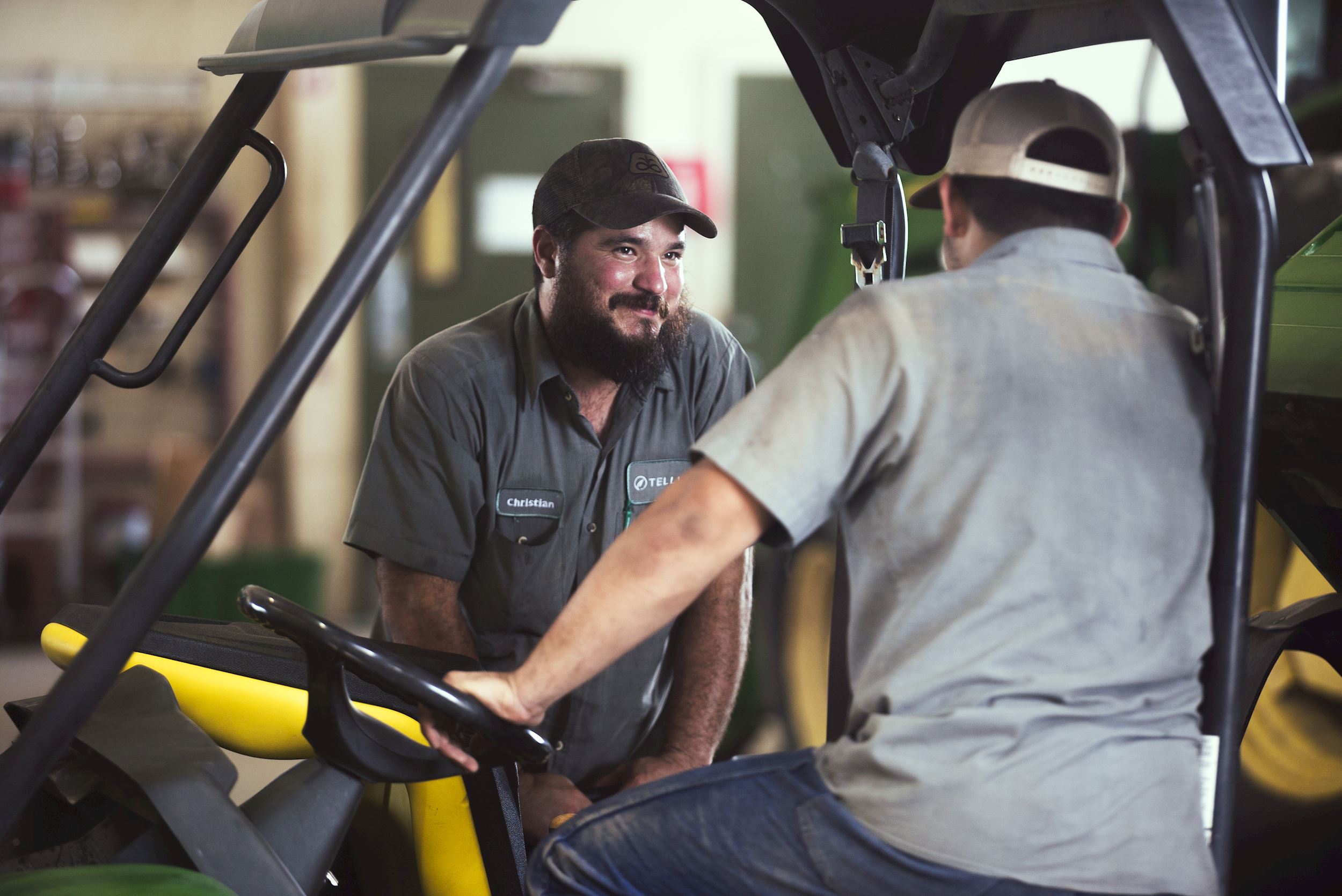 A Tellus Equipment worker helps a customer with their Gator XUV.