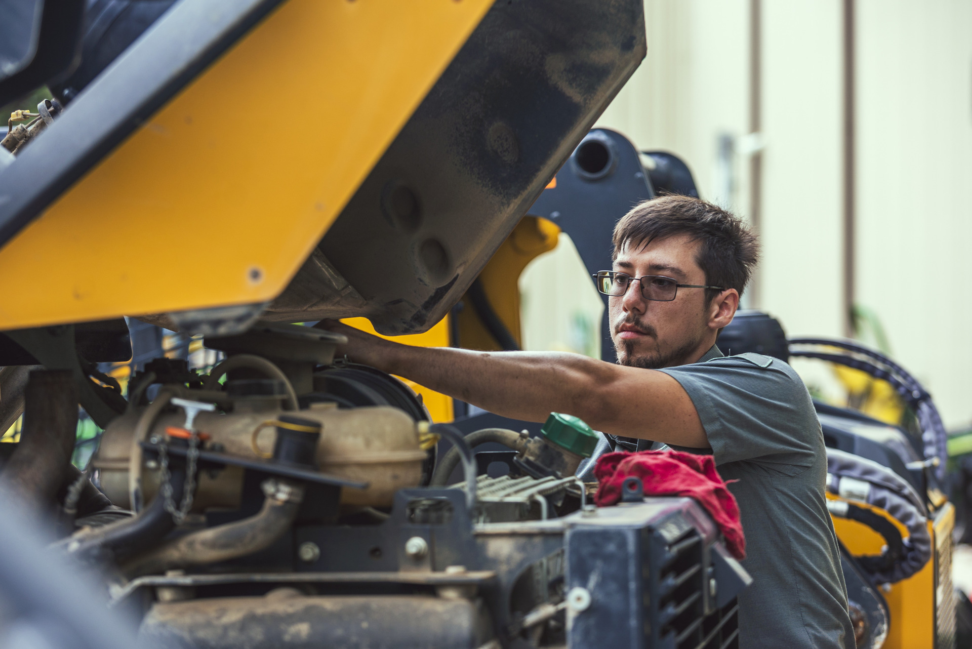 A service department worker checks on a John Deere machine at Tellus Equipment of Texas.