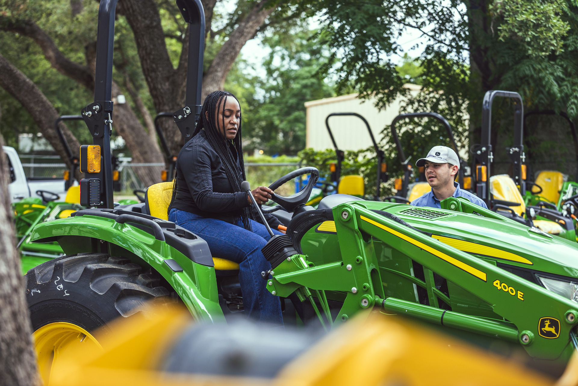 A customer tries out a used John Deere tractor at Tellus Equipment in Texas.