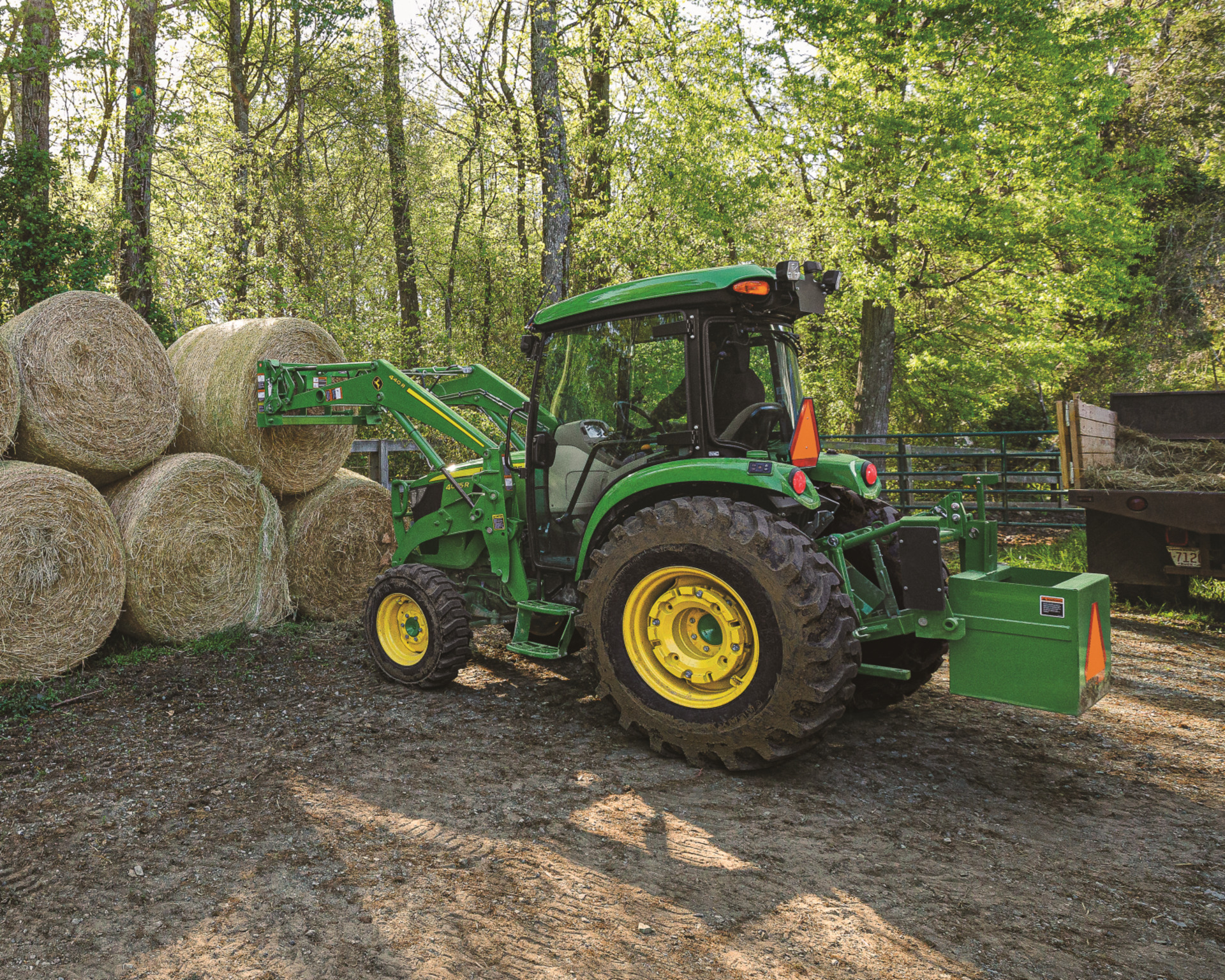 A used tractor lifts hay bales in Texas.