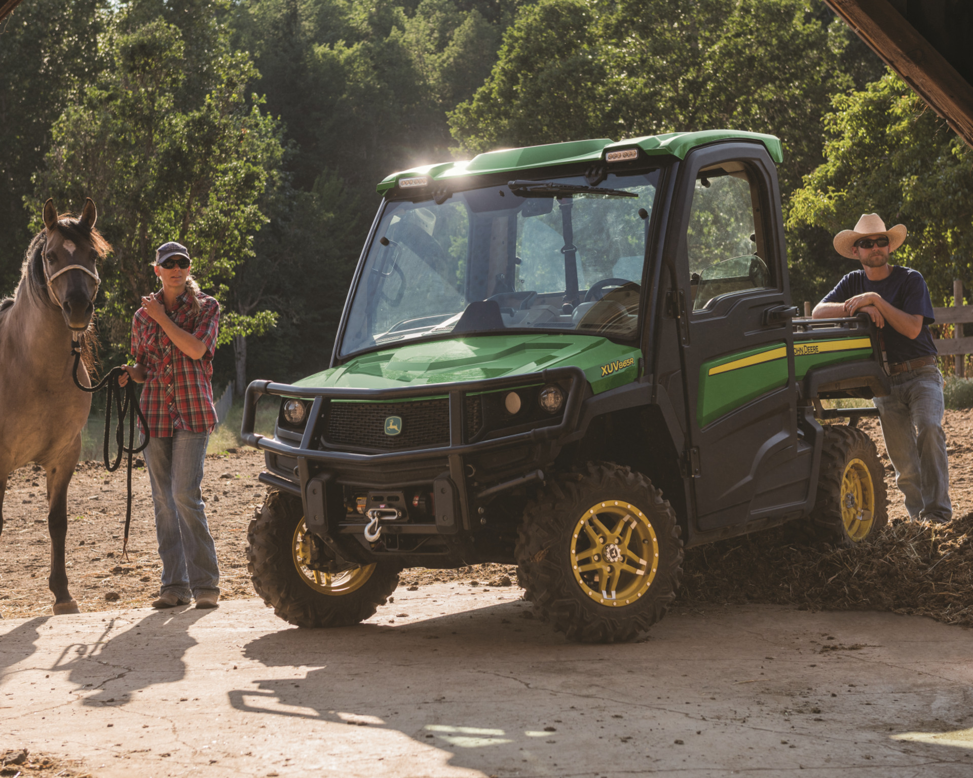 A John Deere Gator on a farm with a horse.