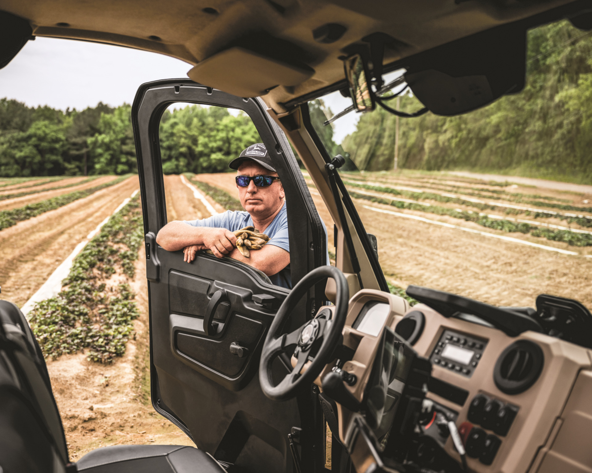 A man leans on the door of his John Deere Gator in Texas.