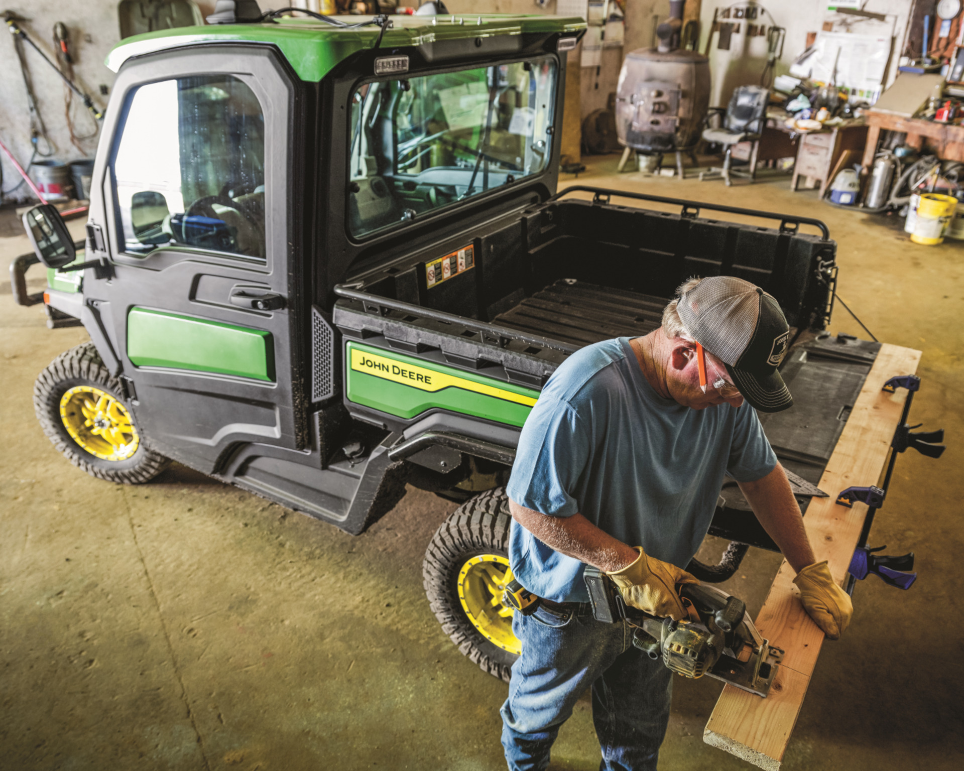 A man uses a Gator trailer bed to cut a wooden board.