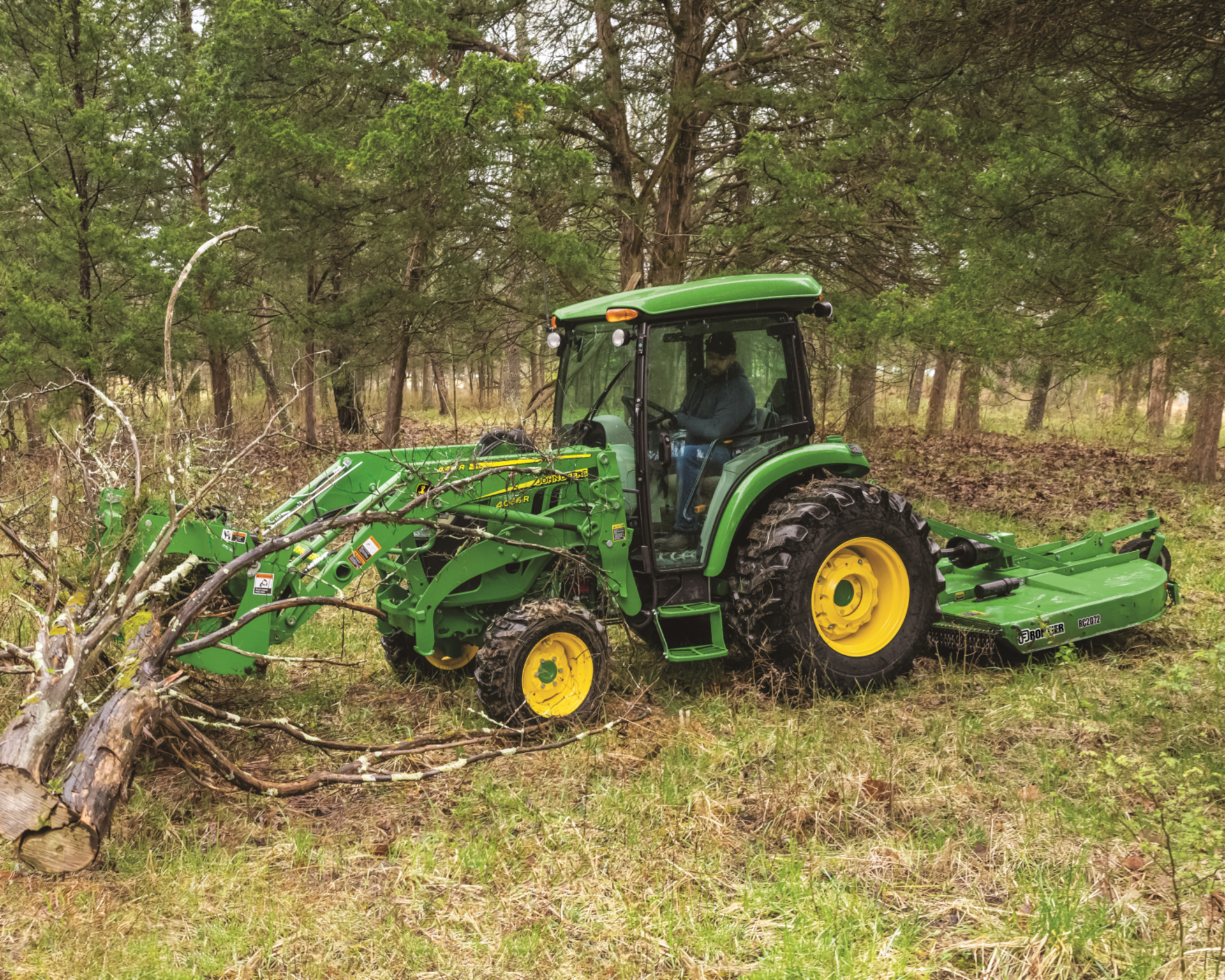 A grapple on a John Deere tractor moves limbs.