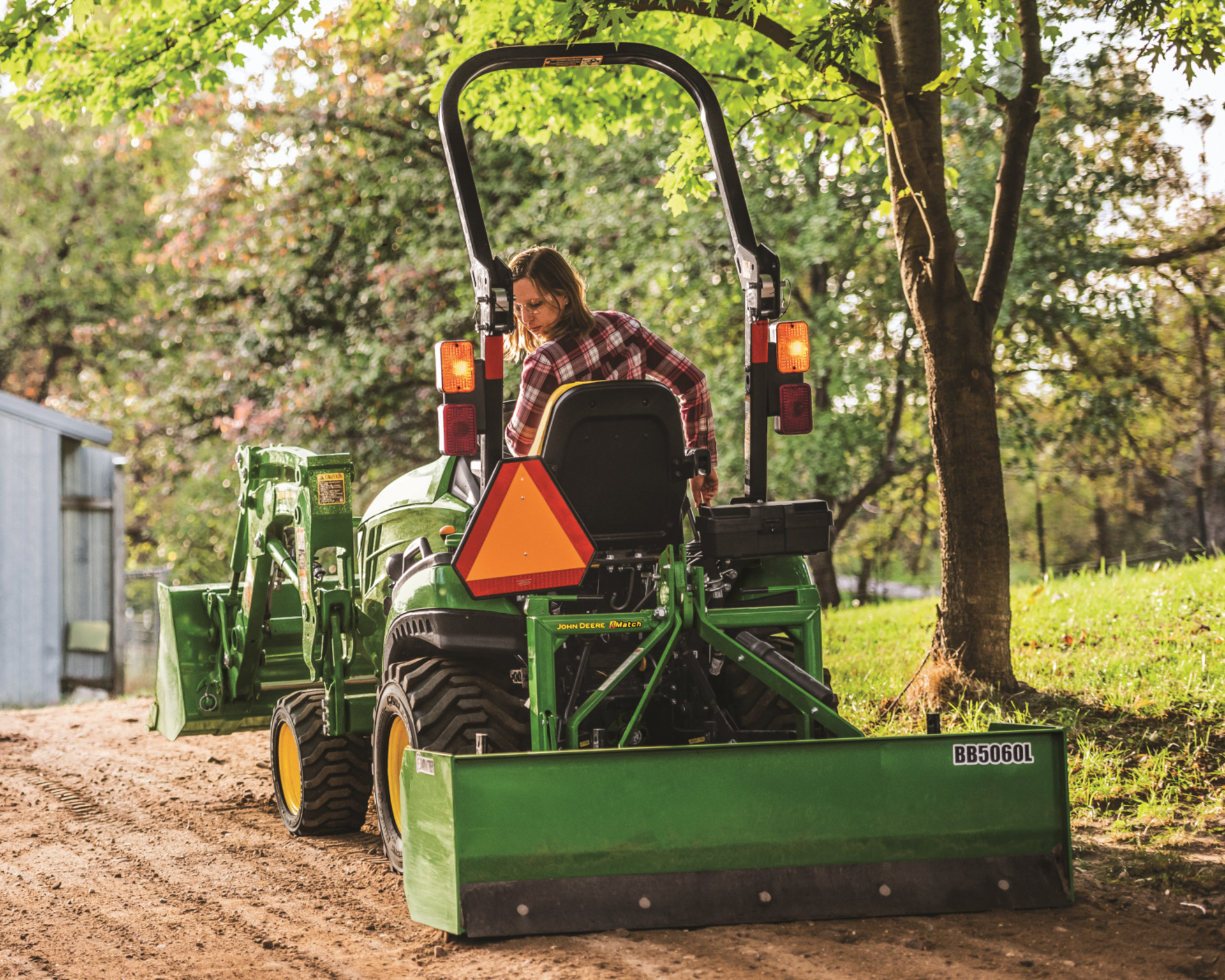A property owners uses a box blade attachment to grade a driveway.