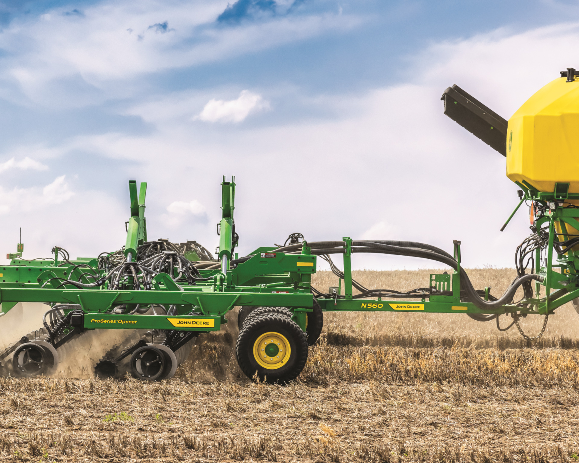 A seeding attachment is pulled by a John Deere tractor in Texas.