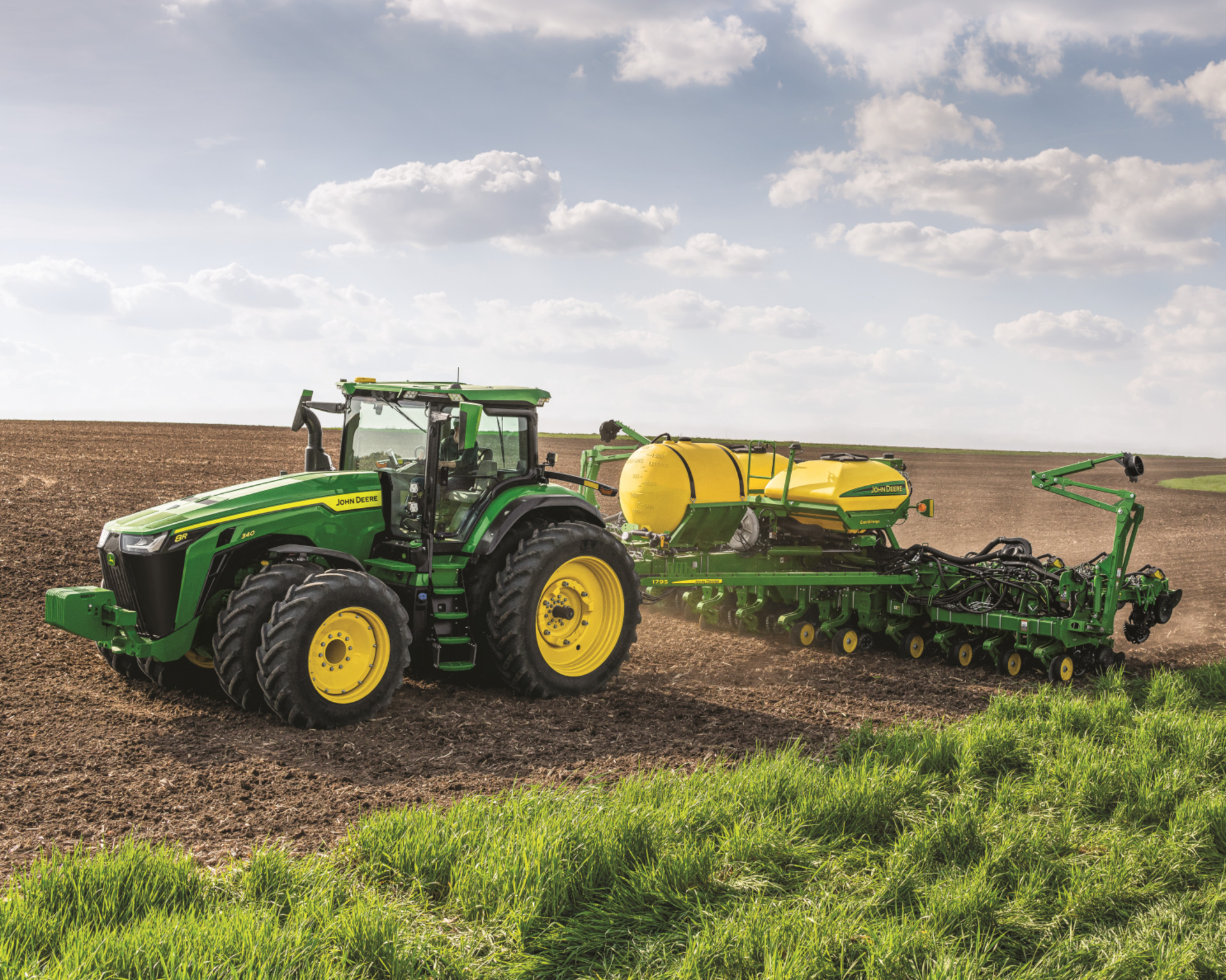A tractor pulls a seeding attachment.