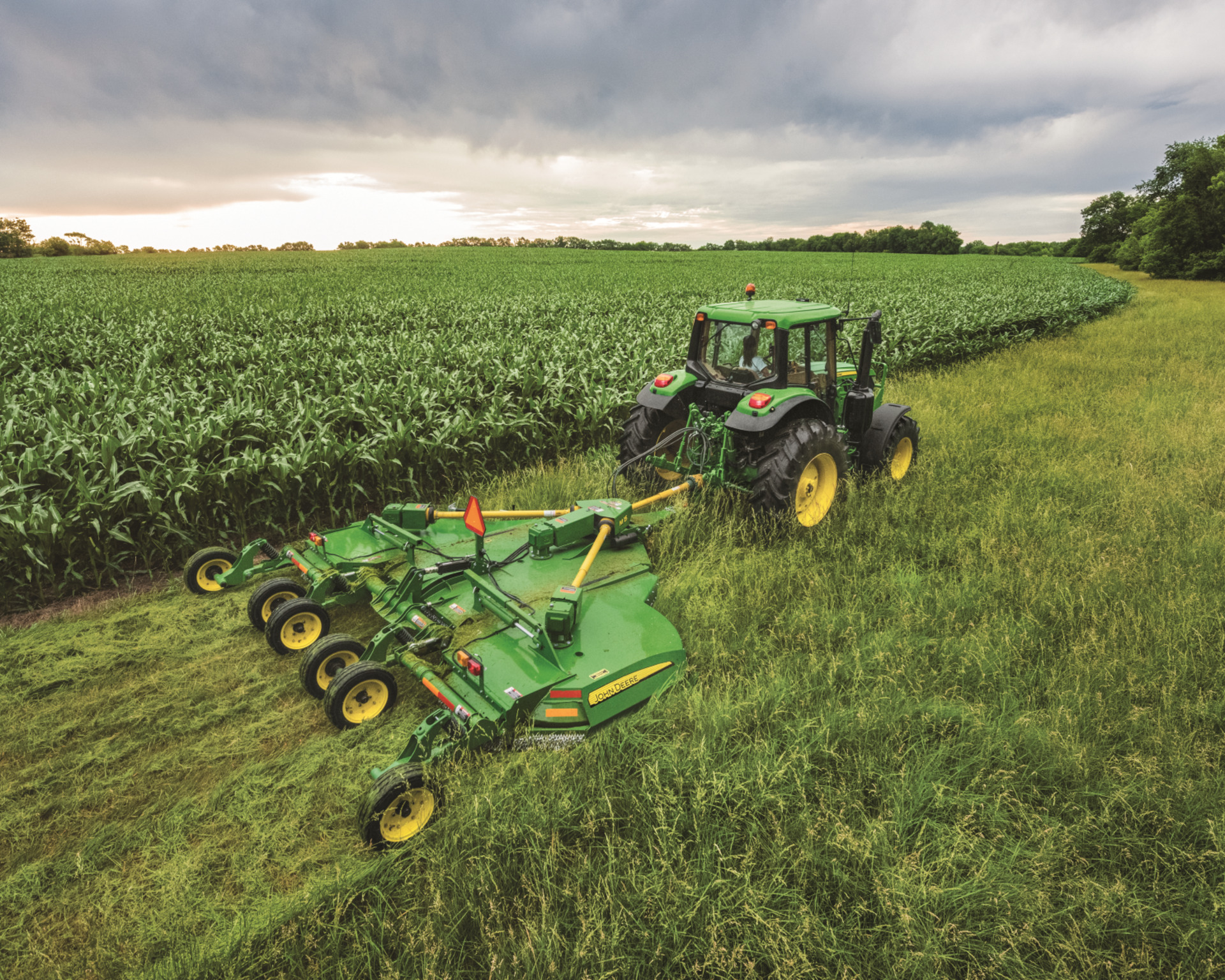 A rotary cutter attachment is pulled by a John Deere tractor through a field in Texas.