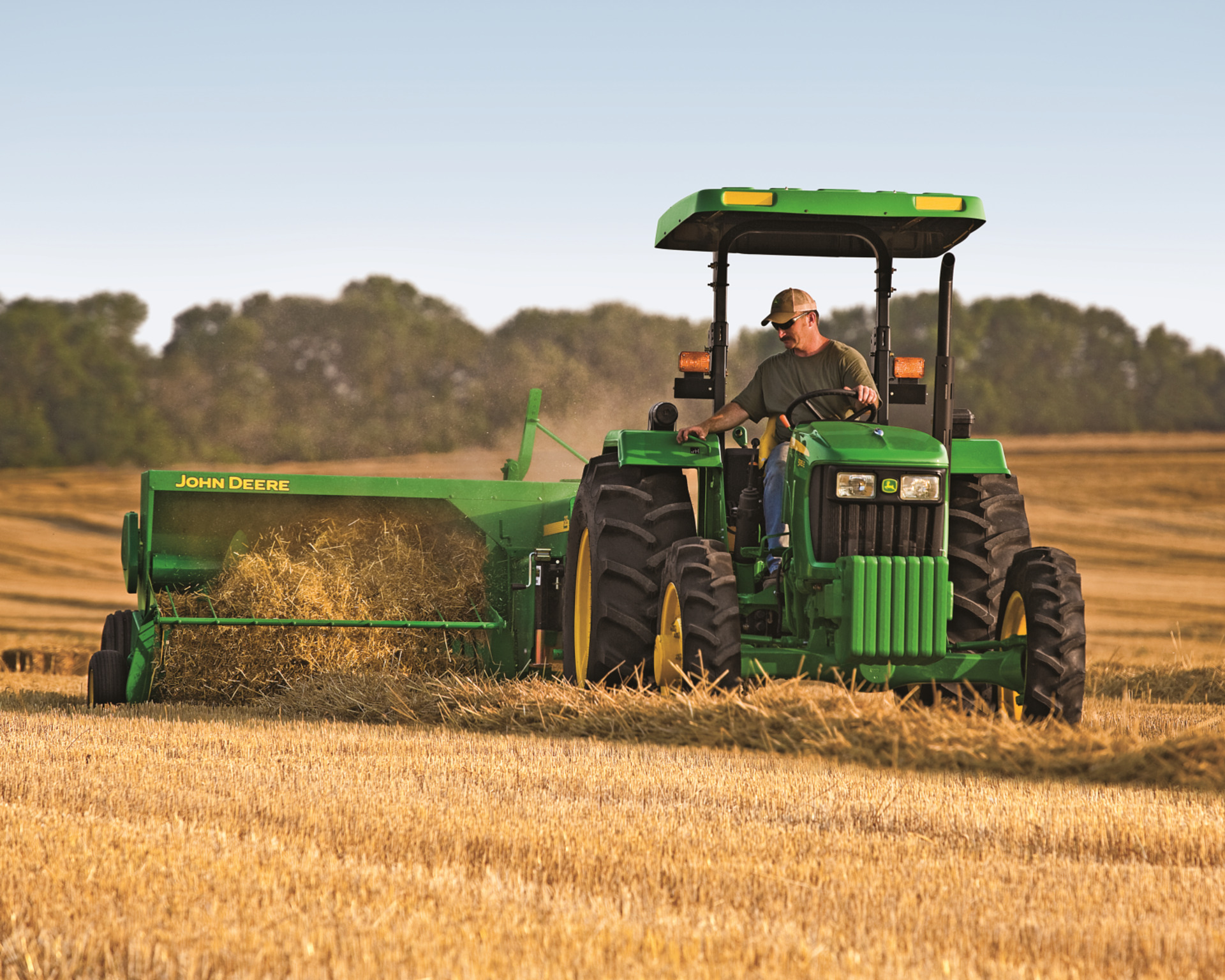 A John Deere tractor pulls a small baler in Texas.