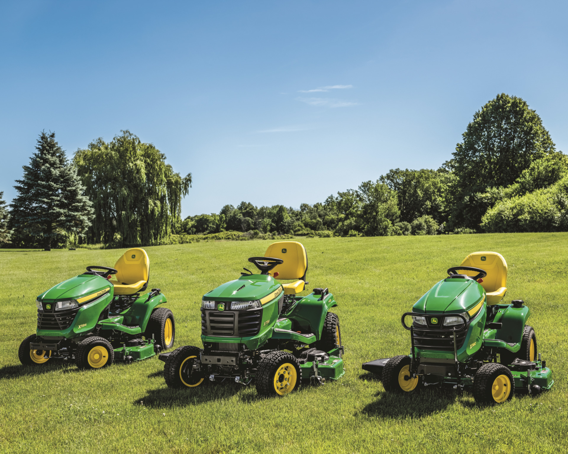 A group of John Deere mowers sits in a field in Texas.