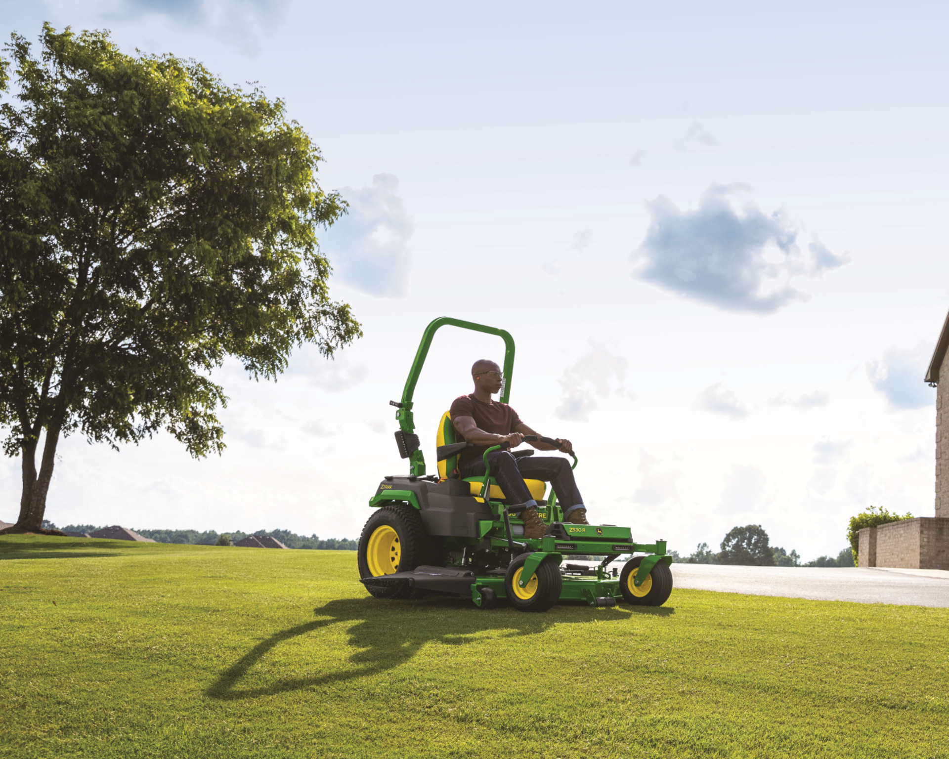 A customer mows their lawn in the spring with a John Deere ZTrak Mower