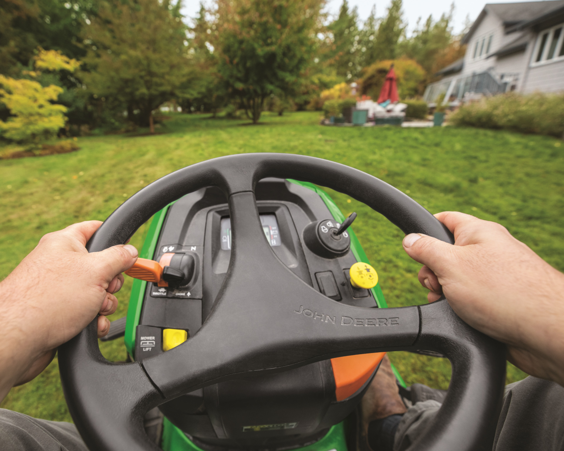 A first person view of a homeowner operating an X300 Series lawn mower.